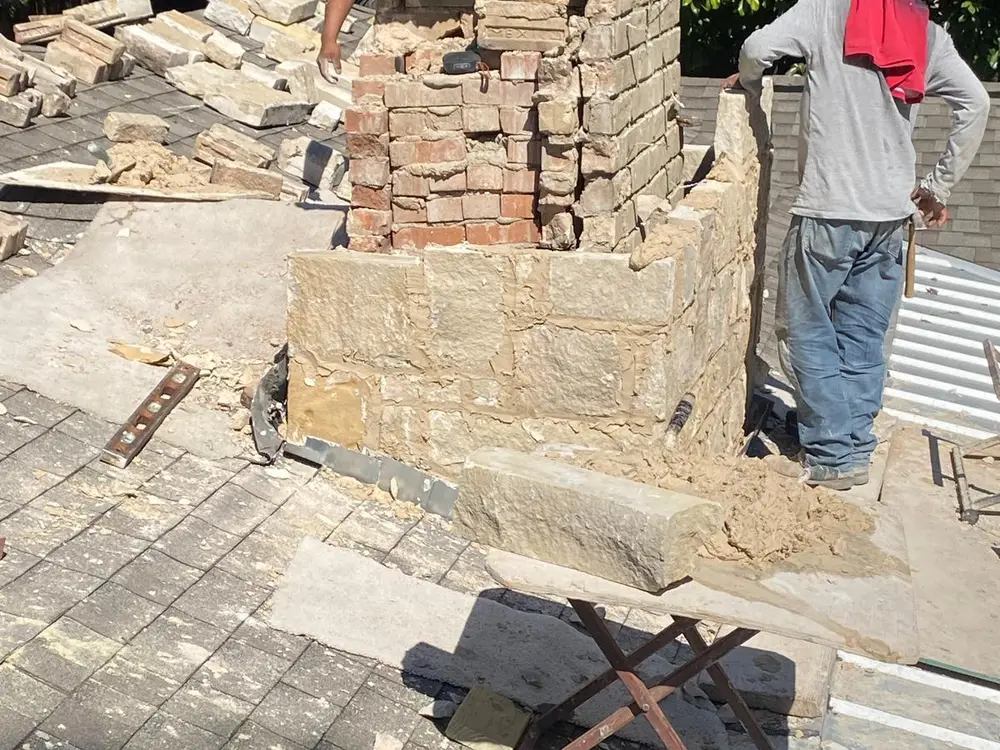 Chimney rebuild in progress, brick and stone going back up