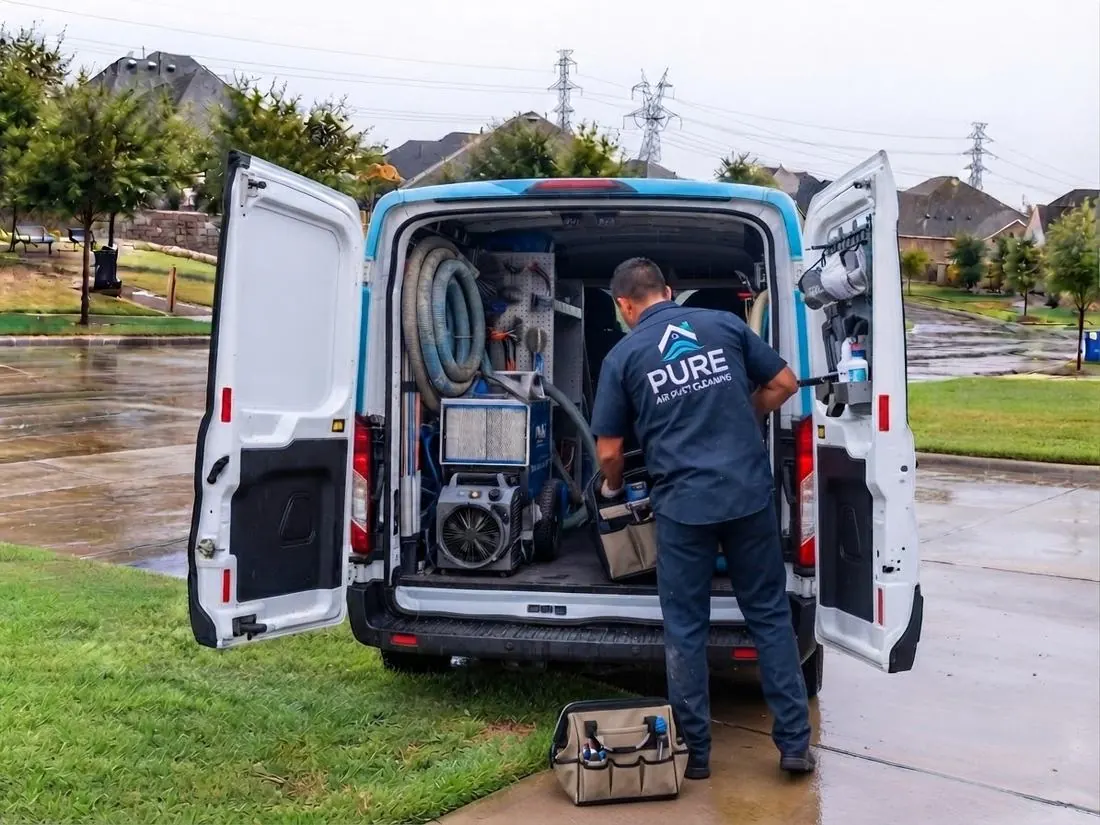 A PUREVENT technician loading the negative-pressure rig and inspection camera from the back of a fully equipped van